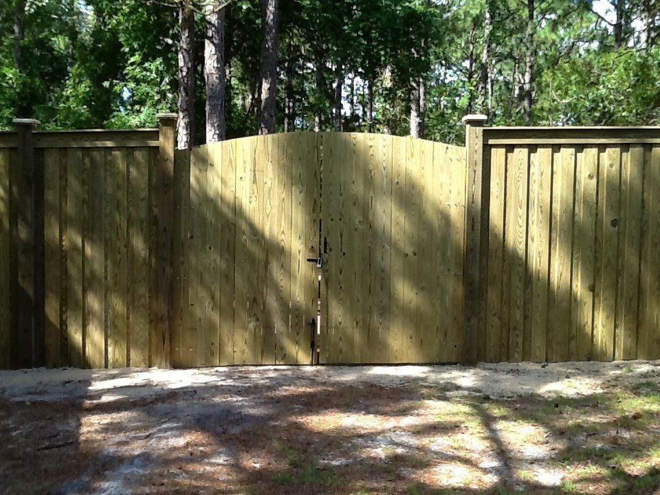 A wooden fence with a gate in the middle of it