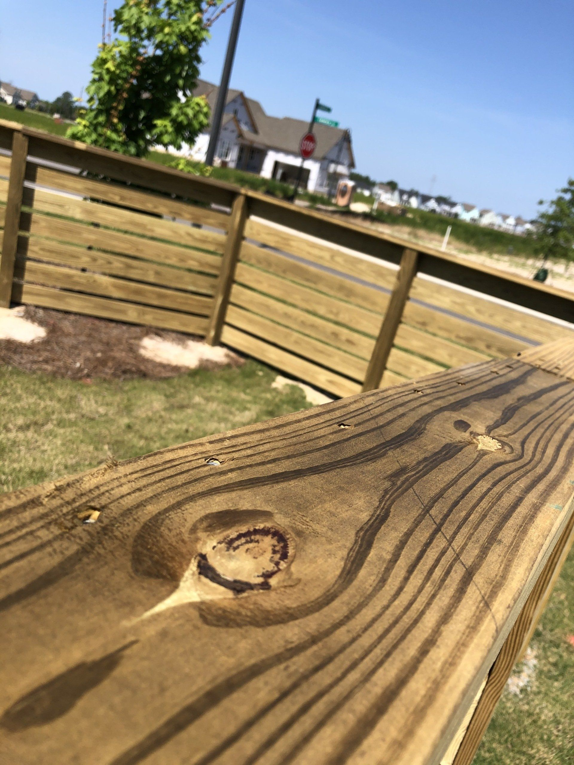 A close up of a piece of wood with a house in the background