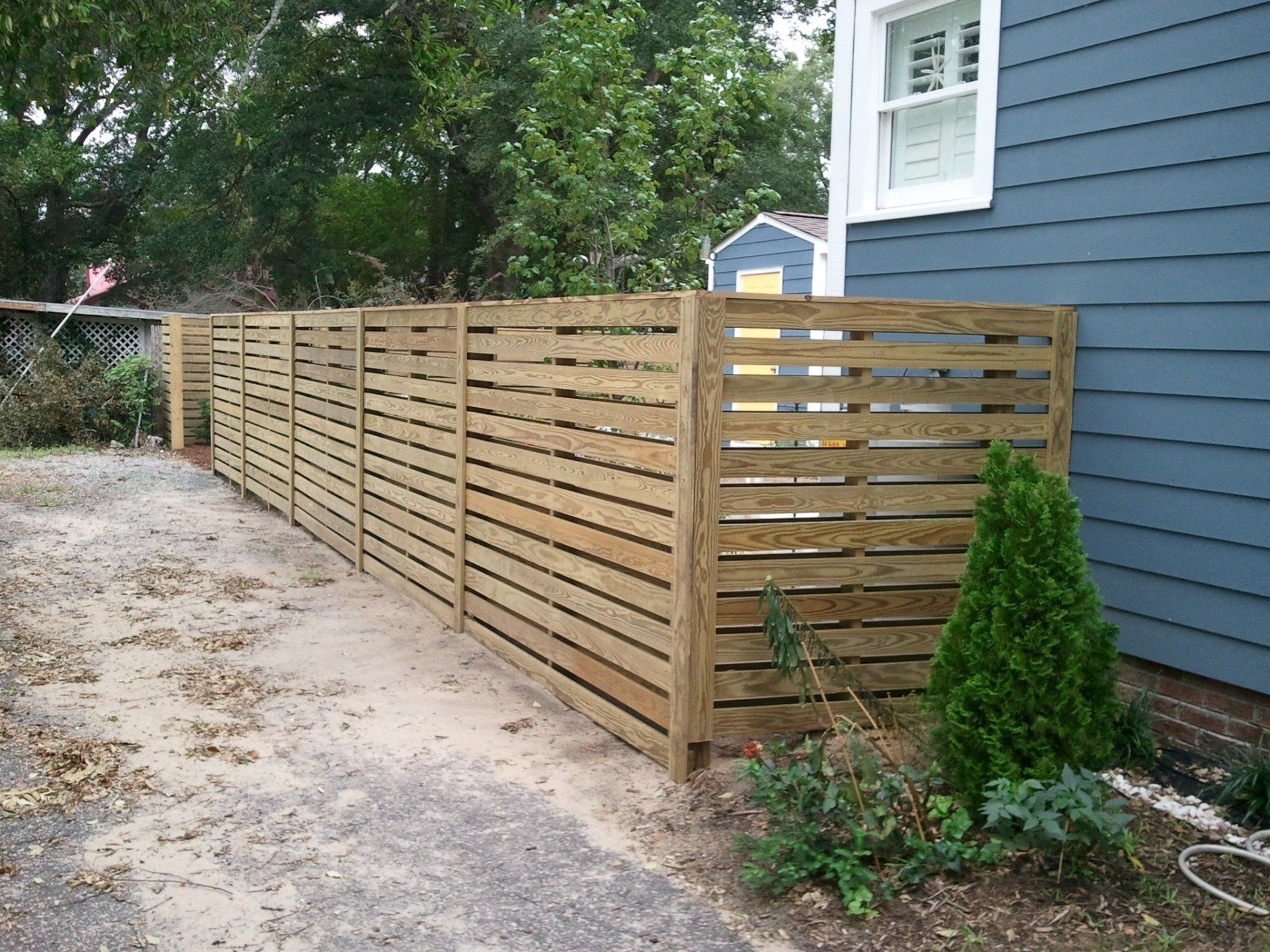 A blue house with a wooden fence in front of it