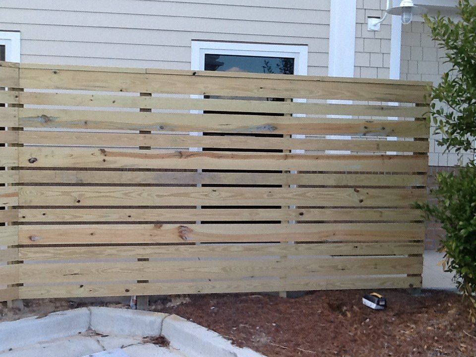 A wooden fence is in front of a house