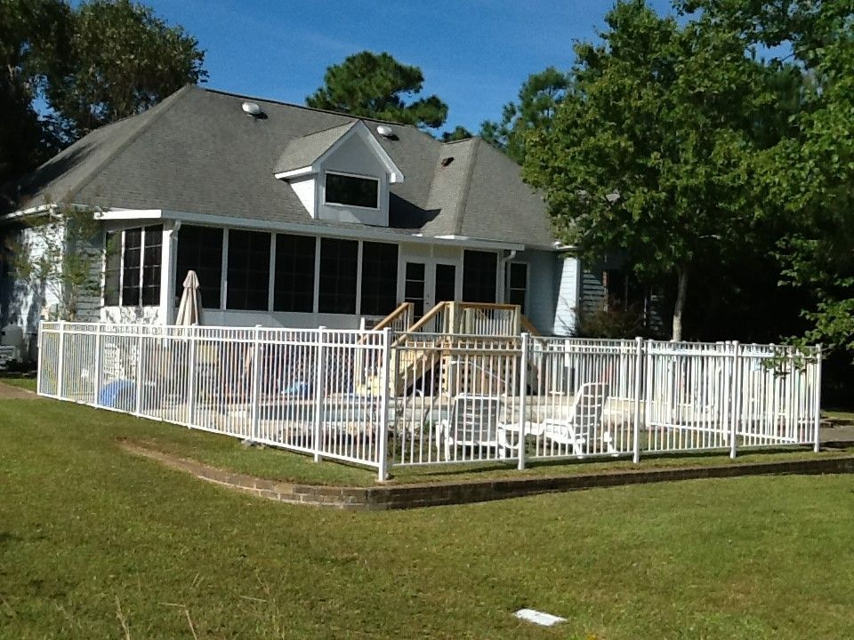 A house with a screened in porch and a fence around it