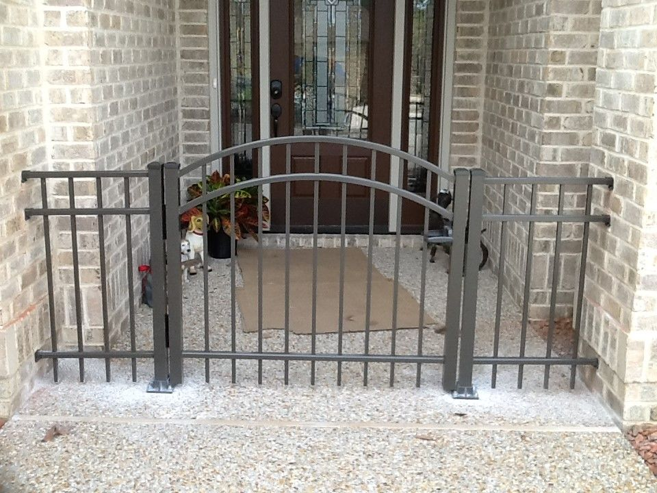 A brick house with a black fence in front of it