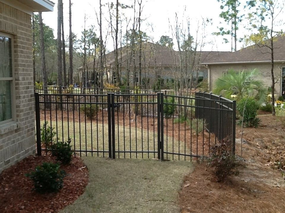 A brick house with a black fence in front of it