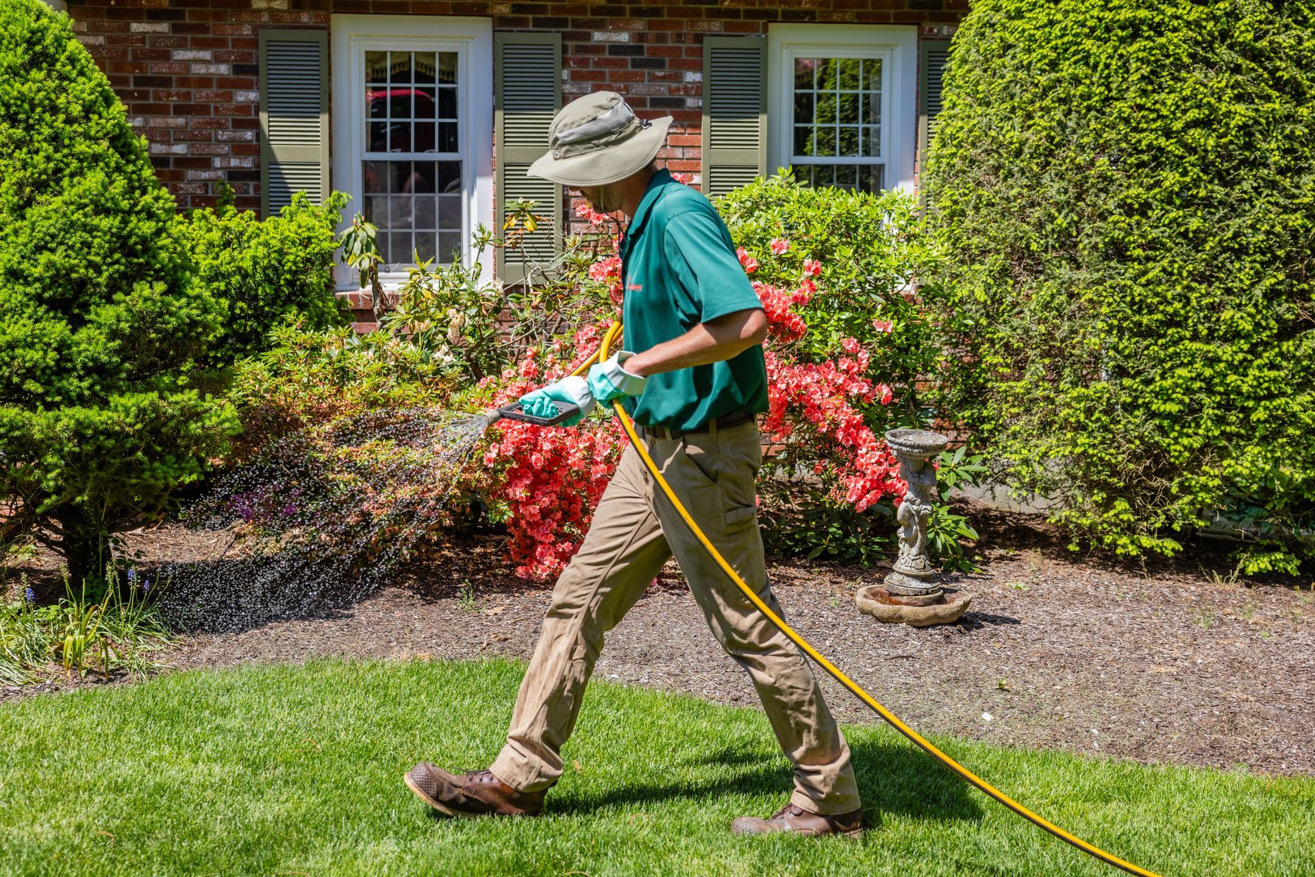 Person operating a yellow stump grinder on grassy ground.
