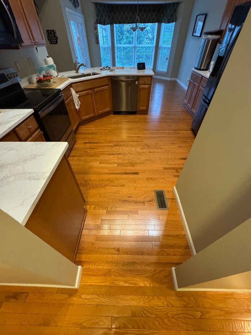 A kitchen with hardwood floors and stainless steel appliances.