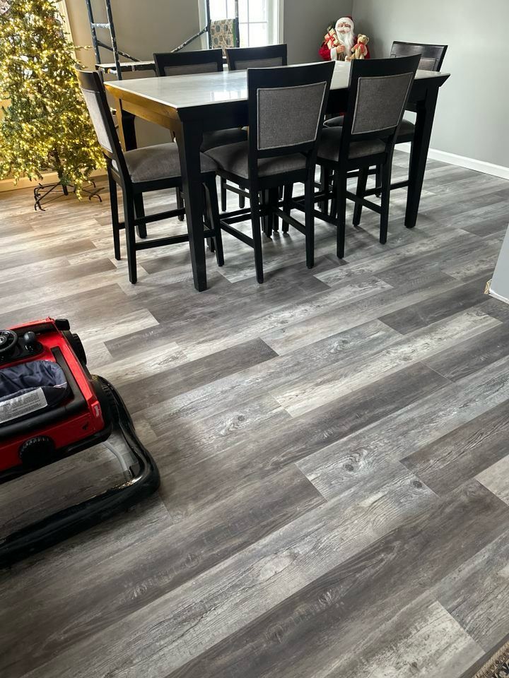 A dining room with a table and chairs and a christmas tree.