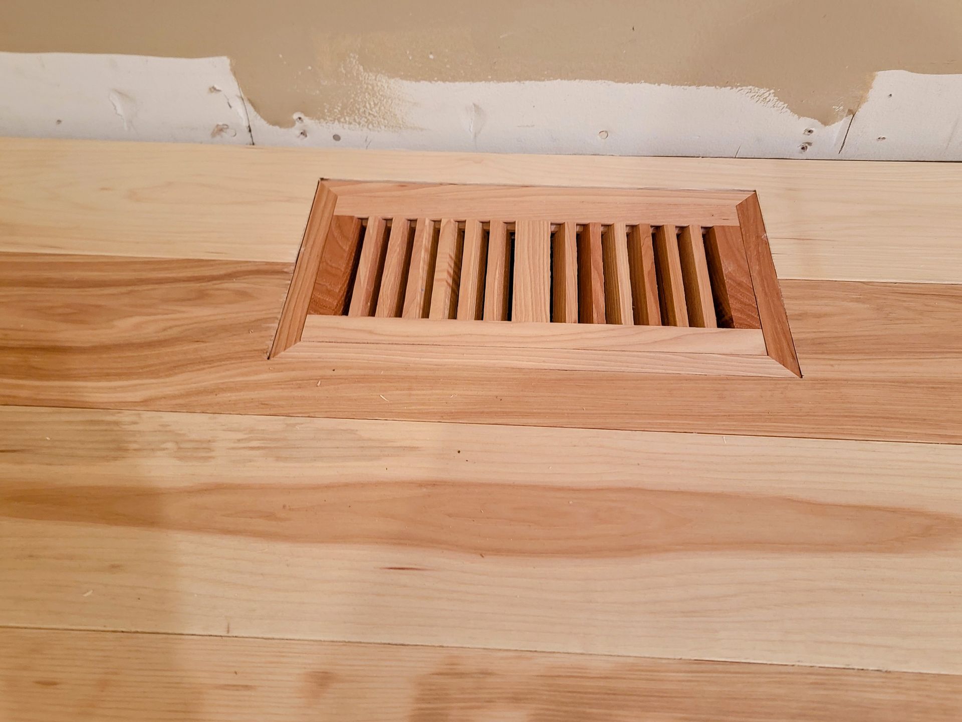 A wooden floor with a vent