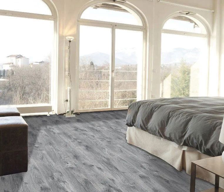 A bedroom with a large bed and a lot of windows