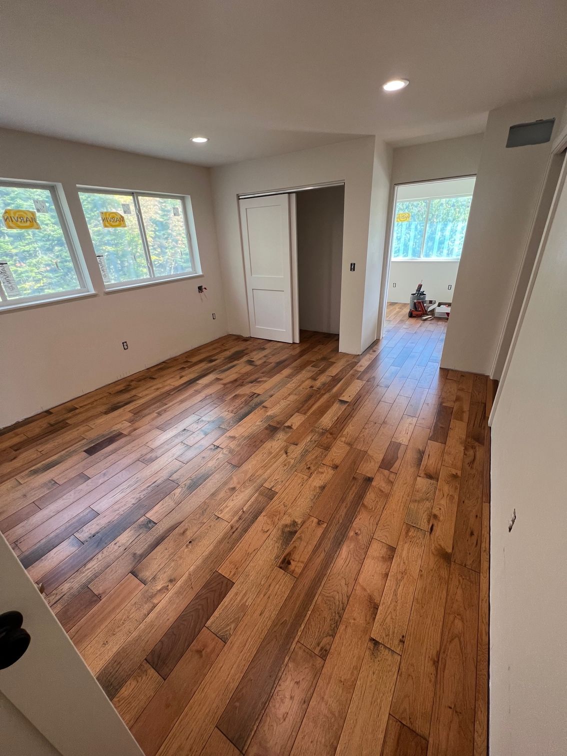 A large room with hardwood floors and lots of windows