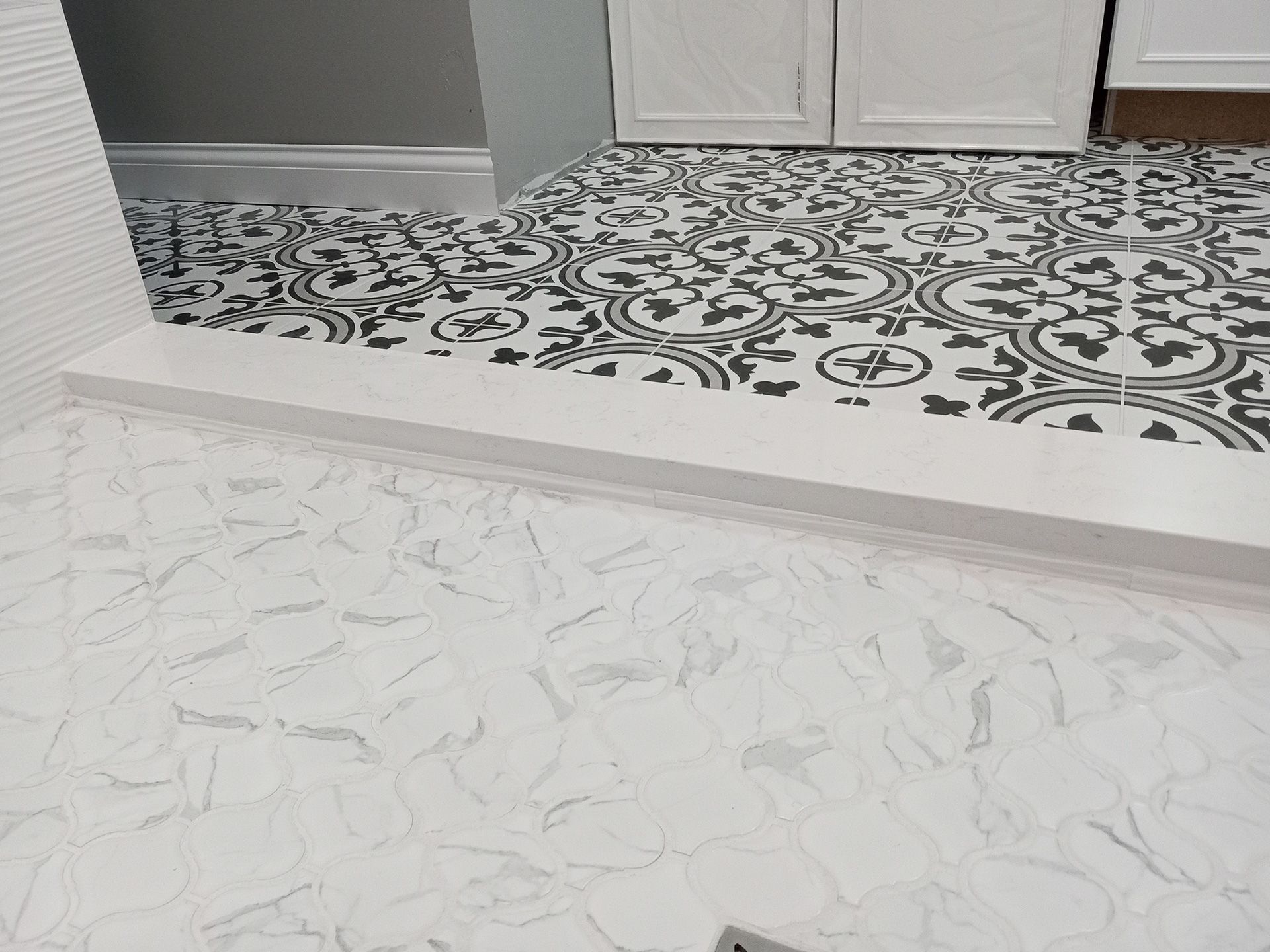 A bathroom with a black and white tile floor