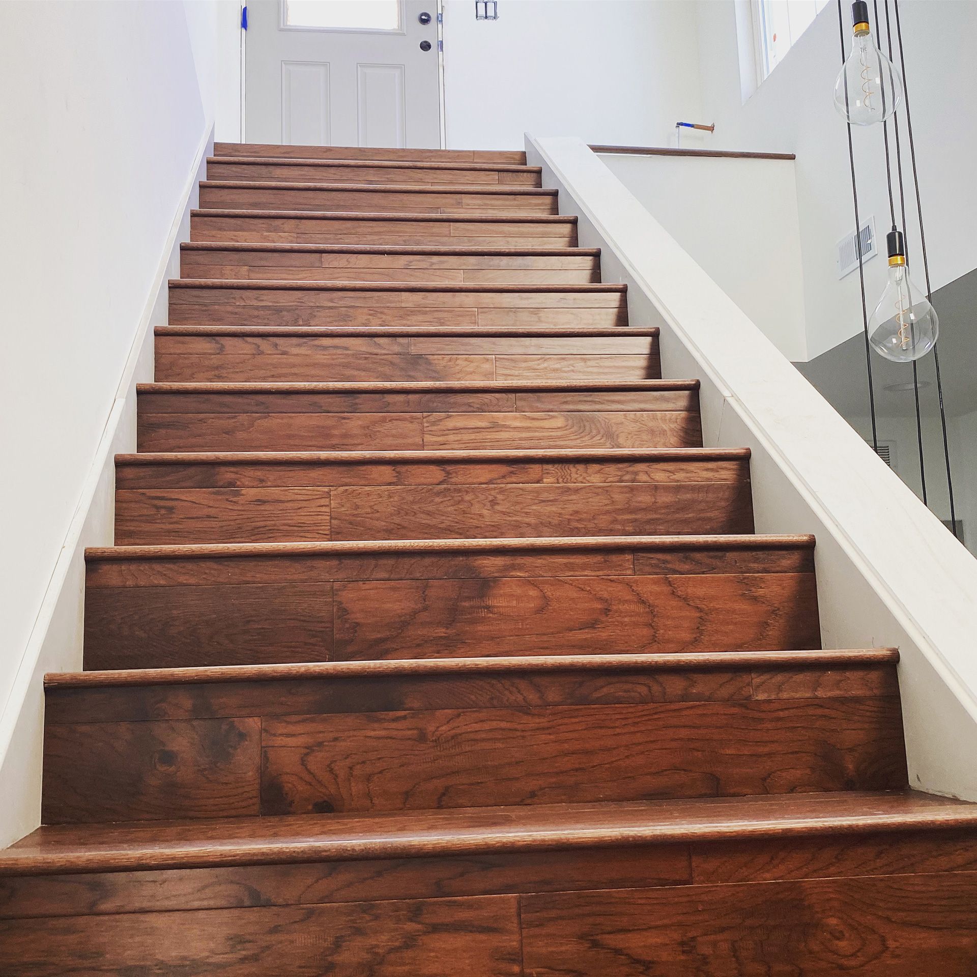 A set of wooden stairs with a white railing