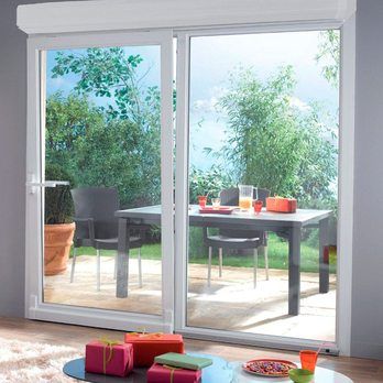 A living room with a sliding glass door leading to a patio with a table with drinks