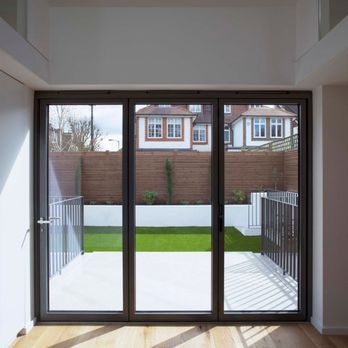 A room with glass doors leading to a backyard