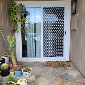 A patio with a sliding glass door and potted plants