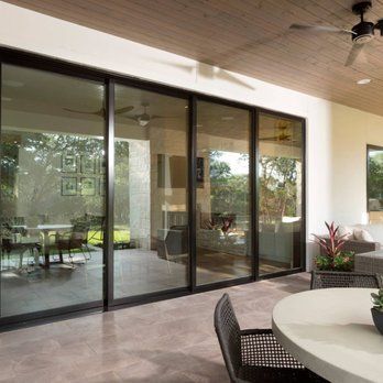 A patio with a table and chairs and a ceiling fan