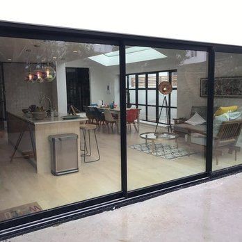 A living room with sliding glass doors leading to a dining room and kitchen