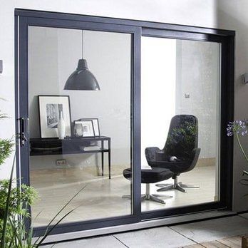 A living room with a chair and ottoman in front of a sliding glass door