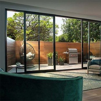 A living room with sliding glass doors leading to a patio with a grill