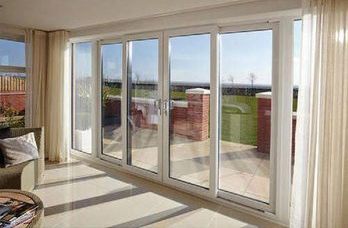A living room with a lot of windows and sliding glass doors