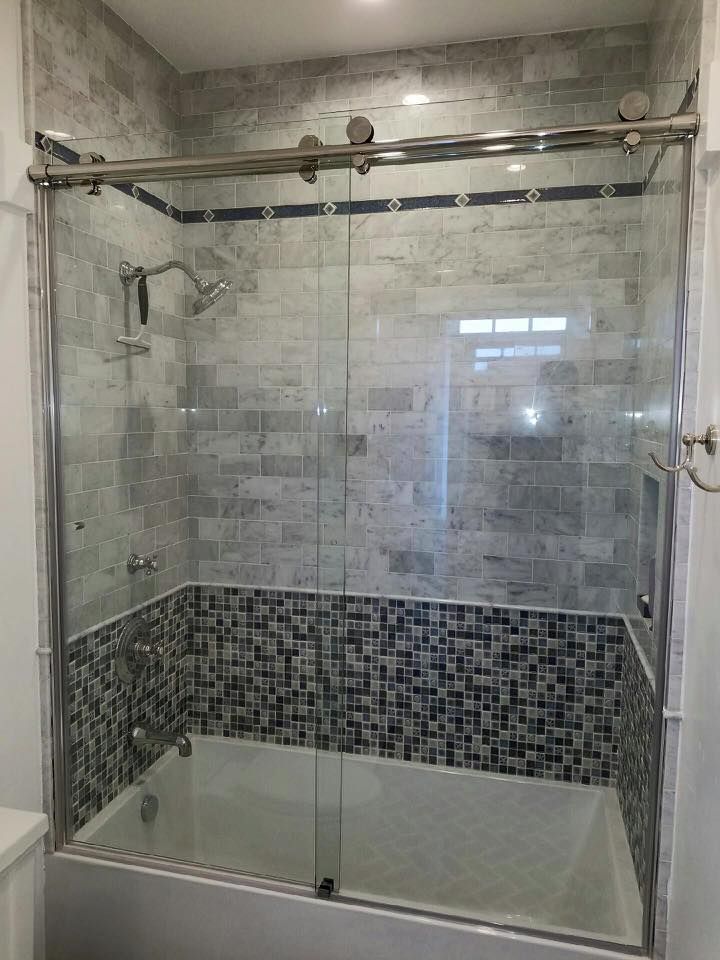 Bathroom with glass shower doors and tiled walls.