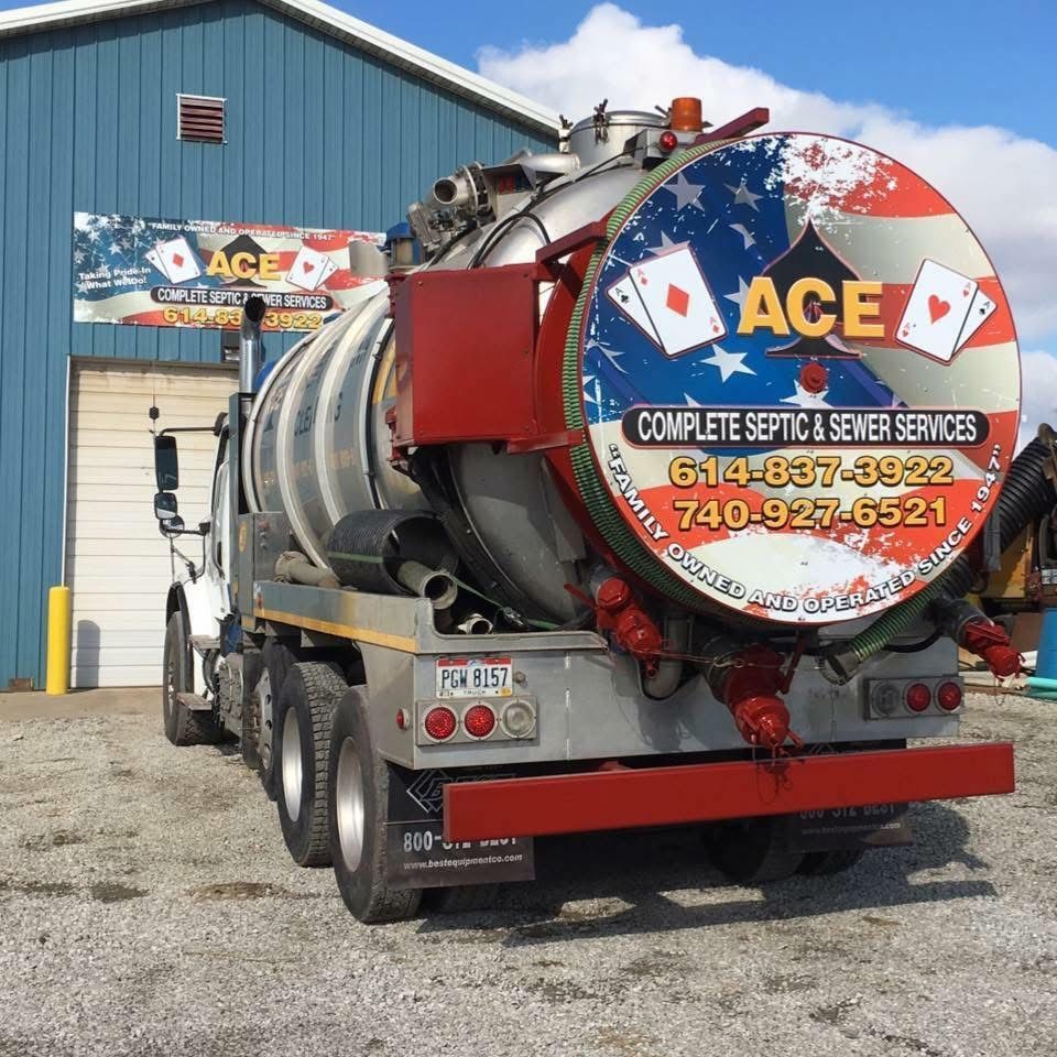 ACE septic service truck parked outside a blue building, rear tank with red and silver branding.