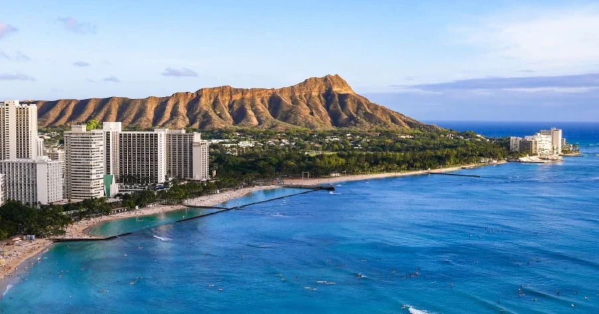 Waikiki Beach with turquoise ocean, white hotels, and Diamond Head crater under a clear sky