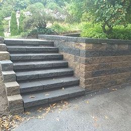 A set of stairs leading up to a stone wall.