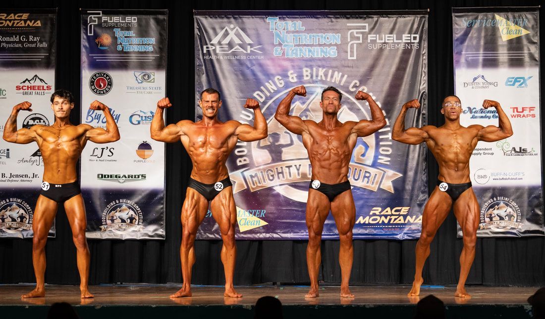 A group of bodybuilders are posing for a picture on a stage.