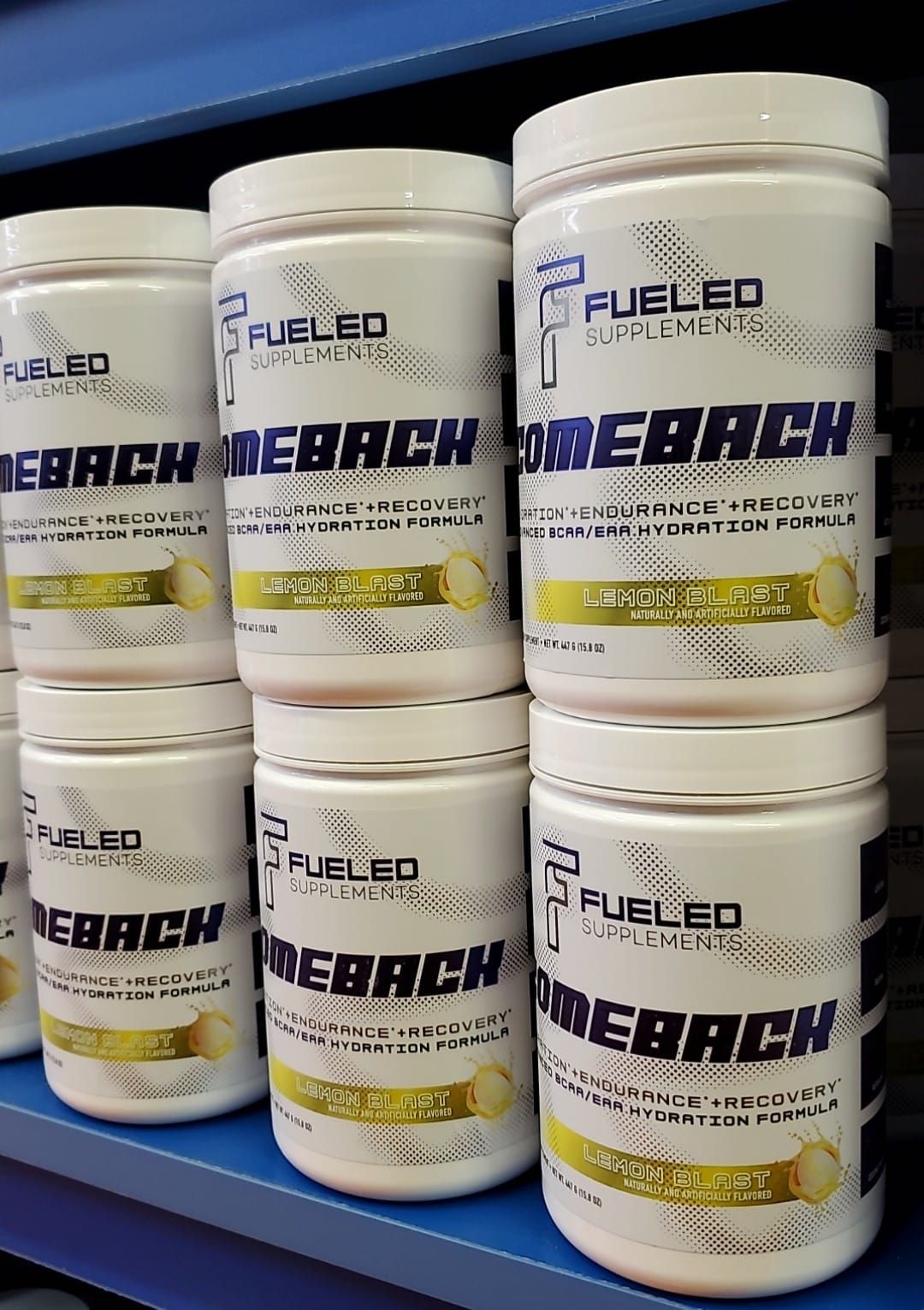 A bunch of bottles of fueled debach are stacked on top of each other on a shelf.