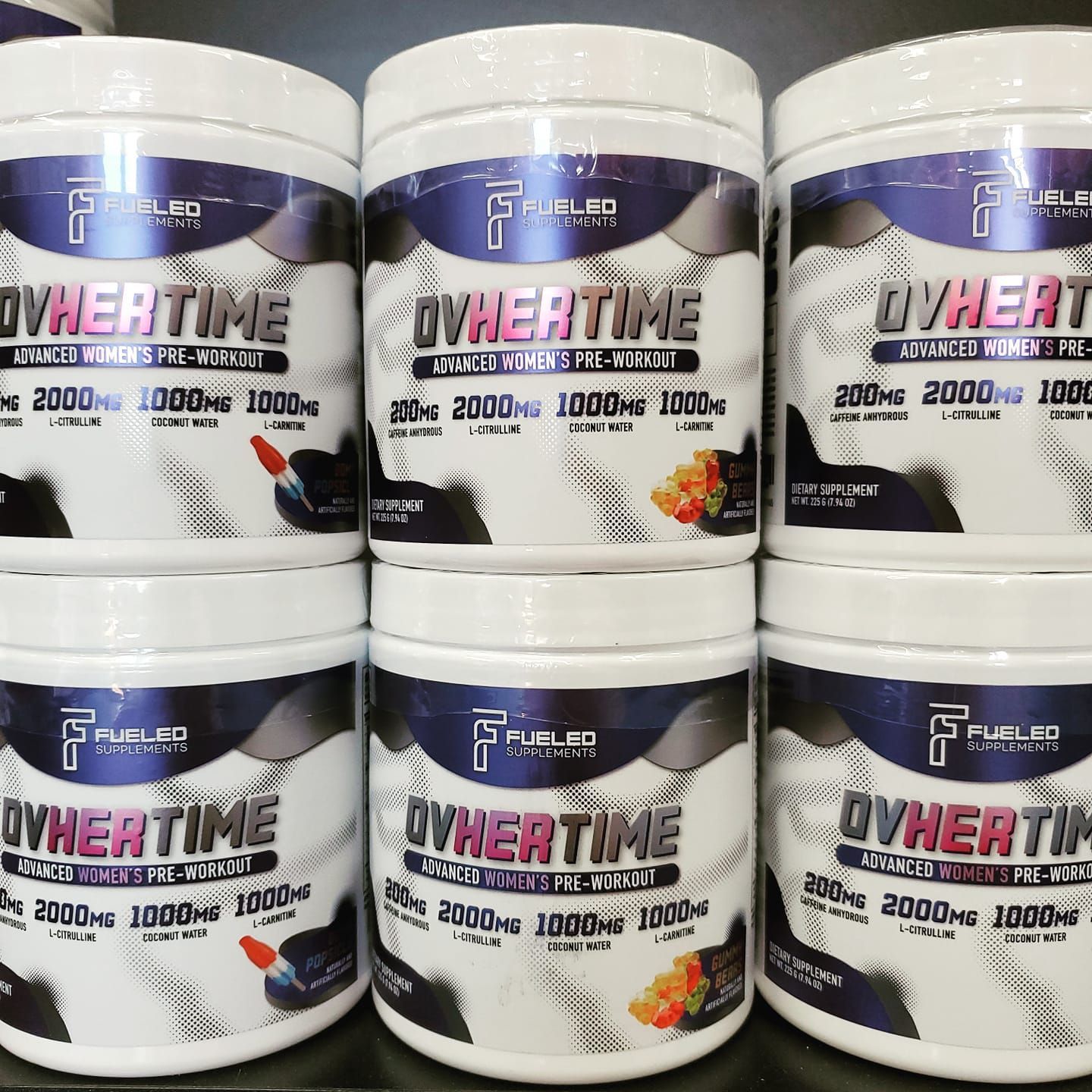 Several bottles of ovhertime are stacked on top of each other.