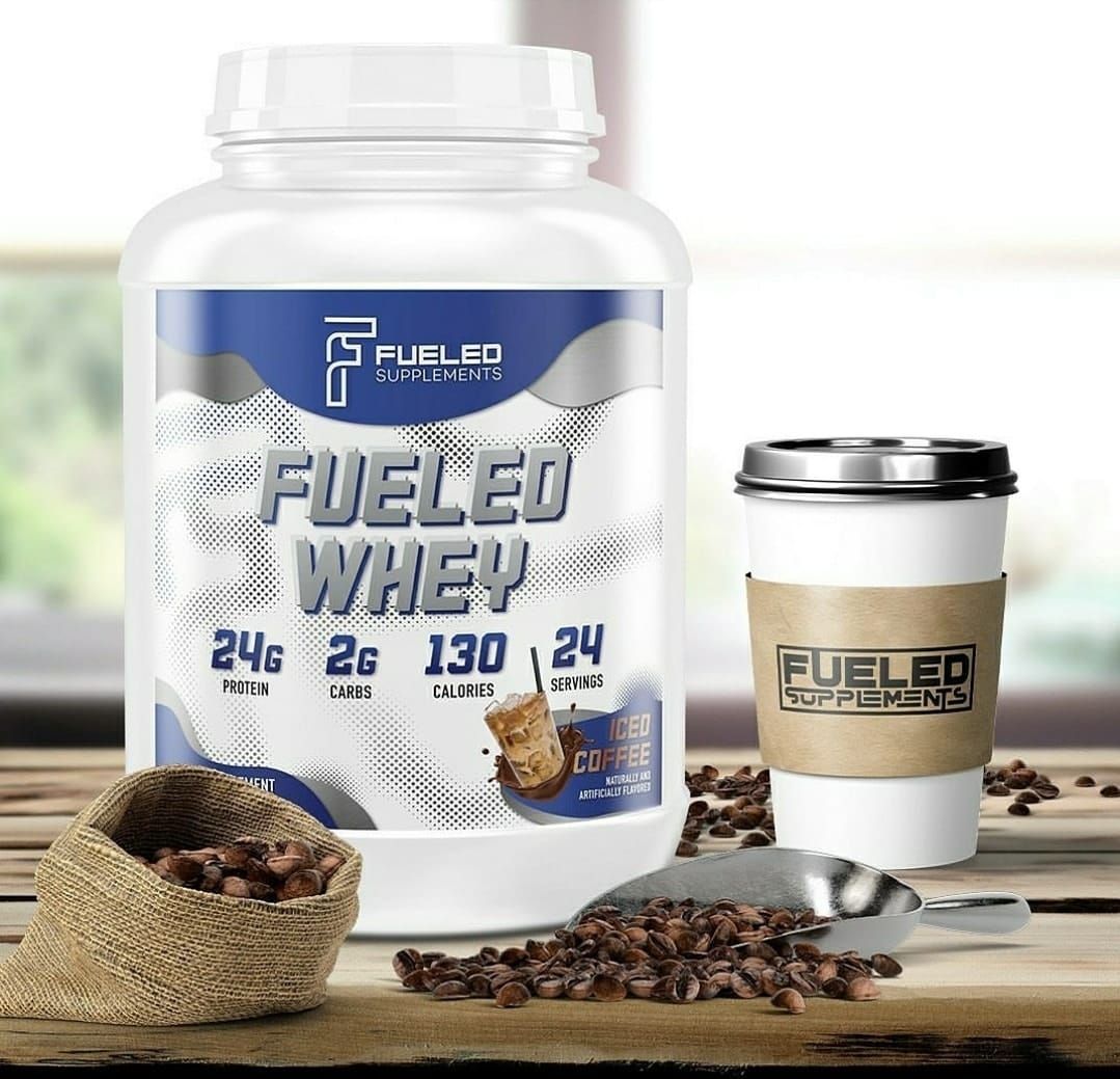 A bottle of fueled whey protein powder and a cup of coffee on a wooden table.