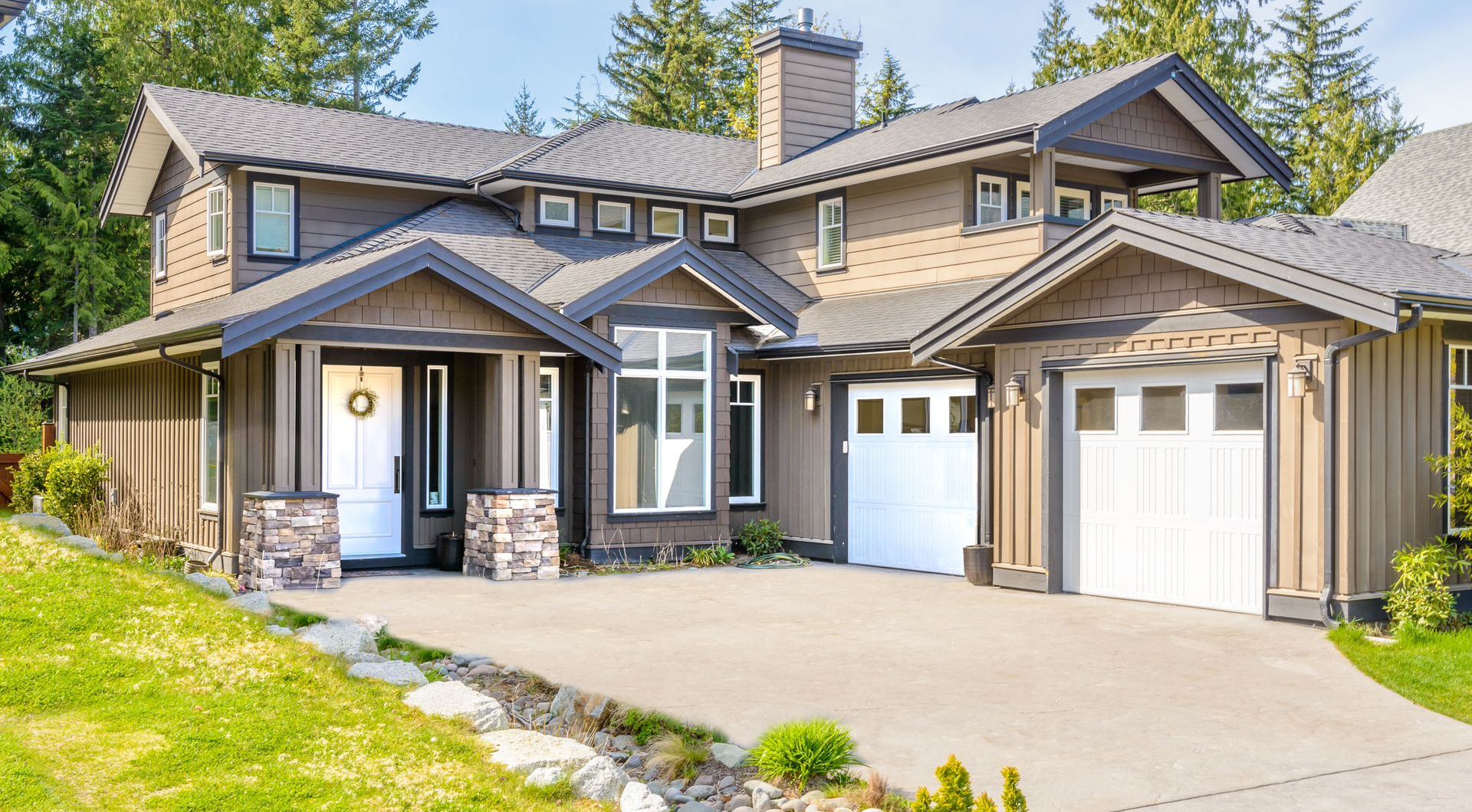 Modern two-story house with stone and wood exterior, garage, and landscaped front yard