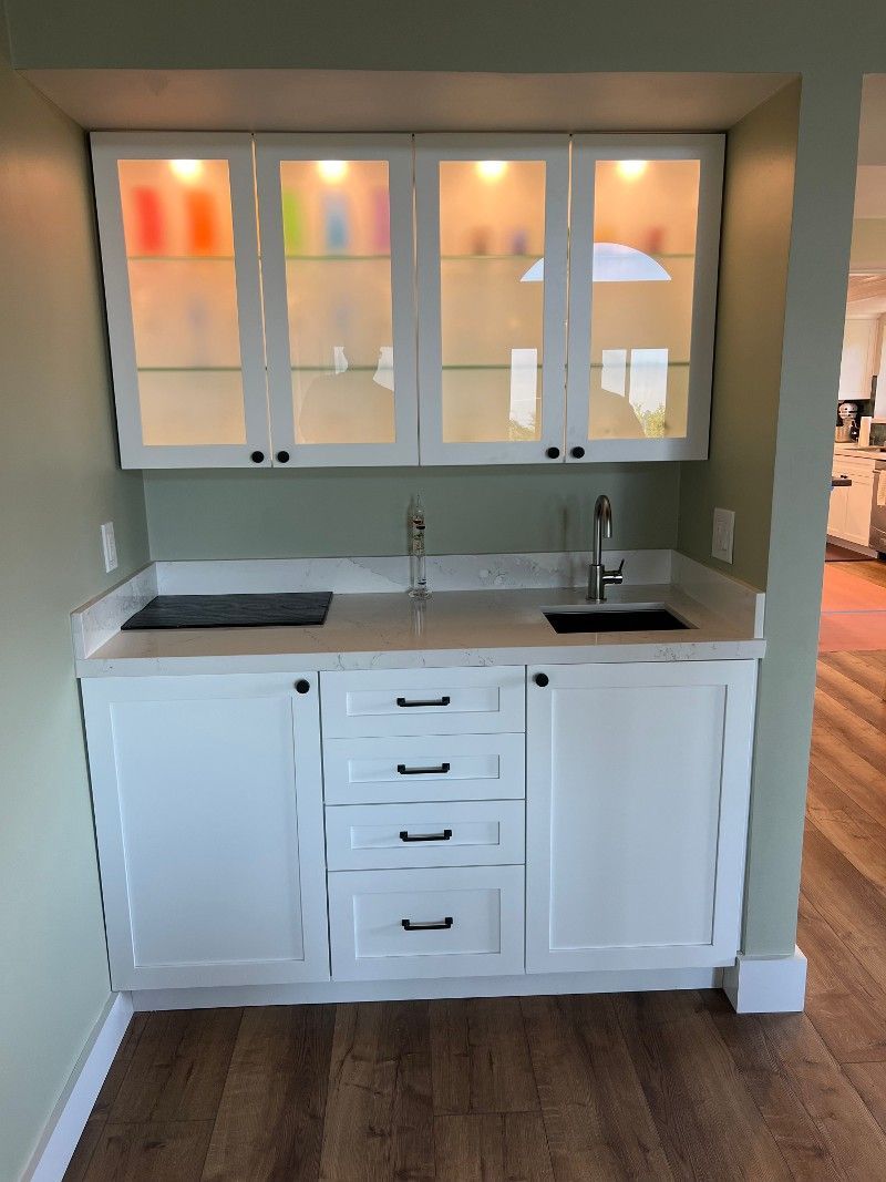 A kitchen with white cabinets and a sink