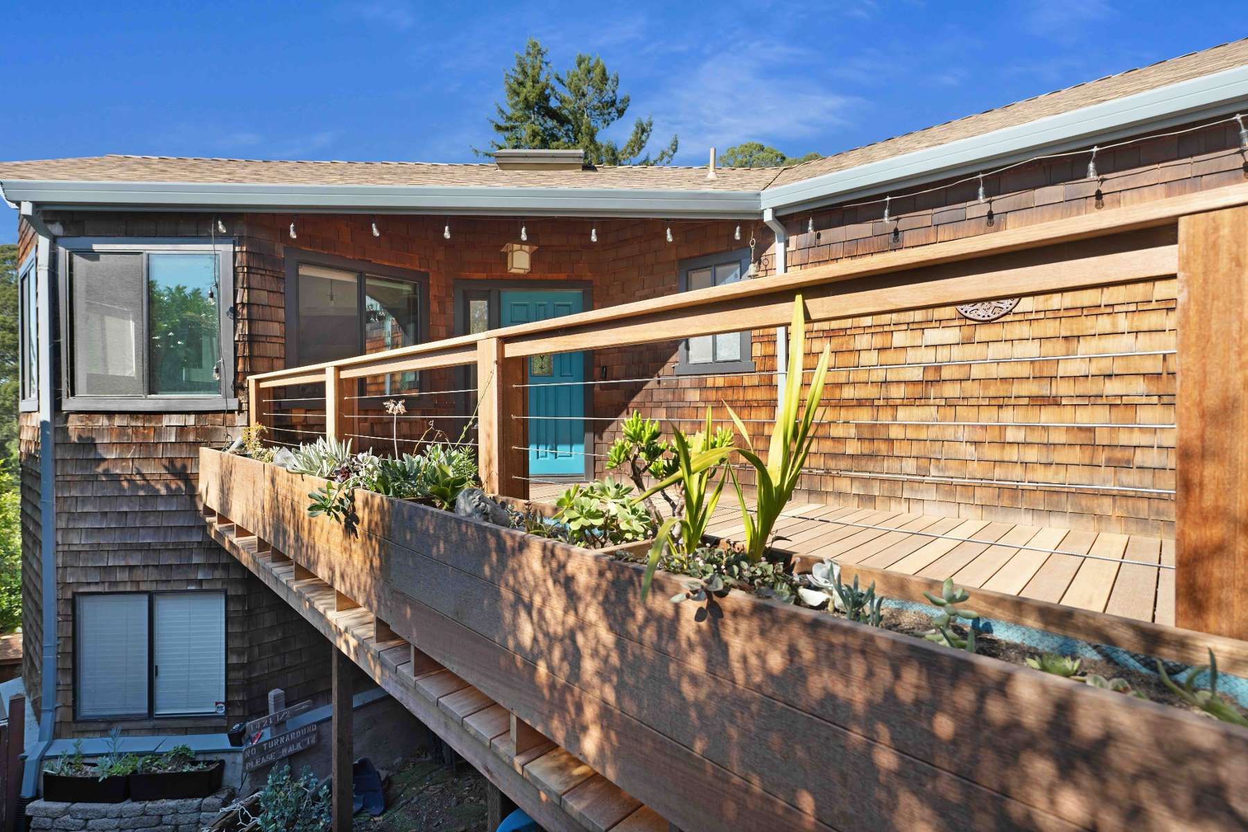 A house with a wooden deck and stairs leading up to it