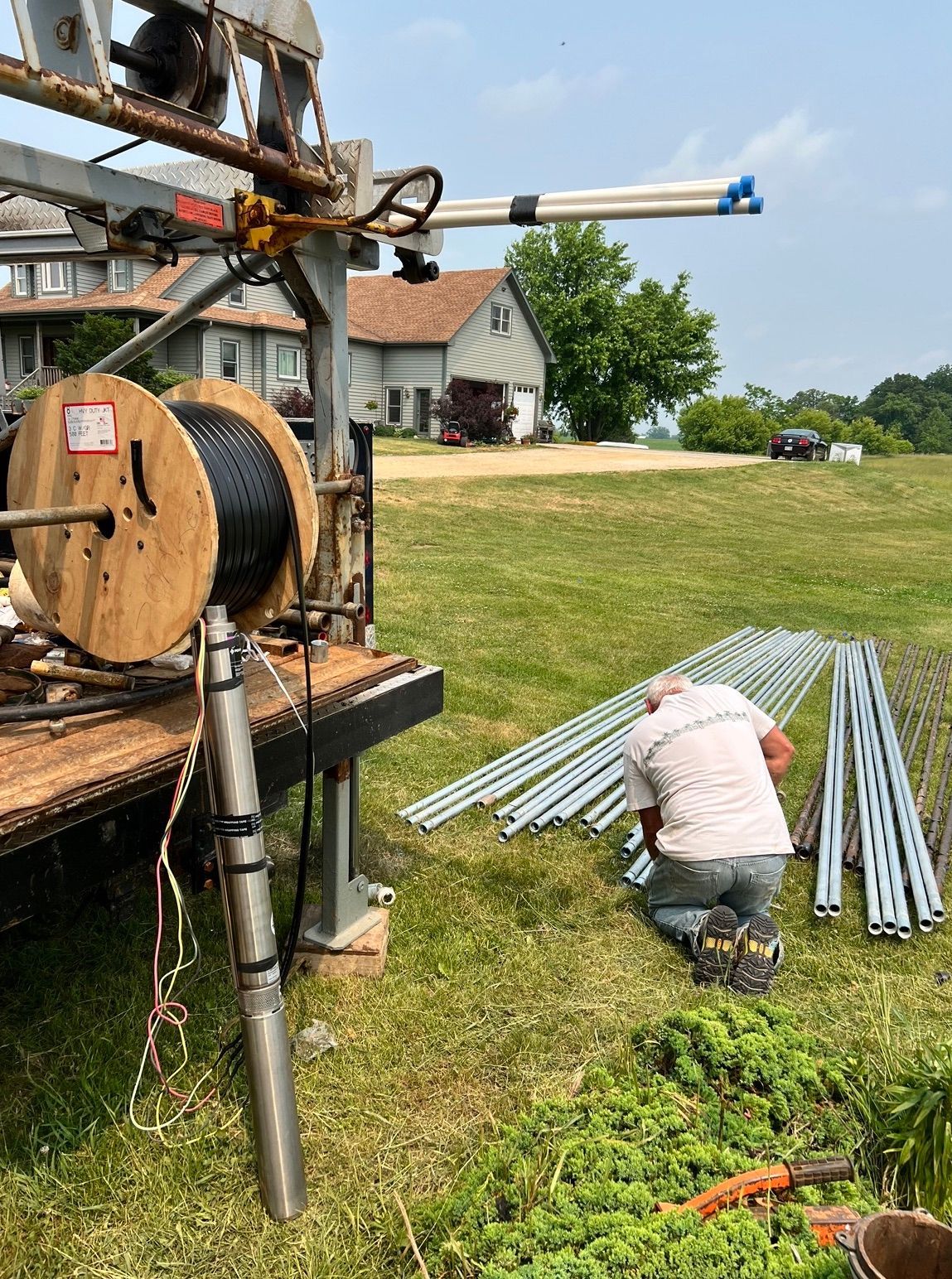 a man is kneeling down in a field next to a machine