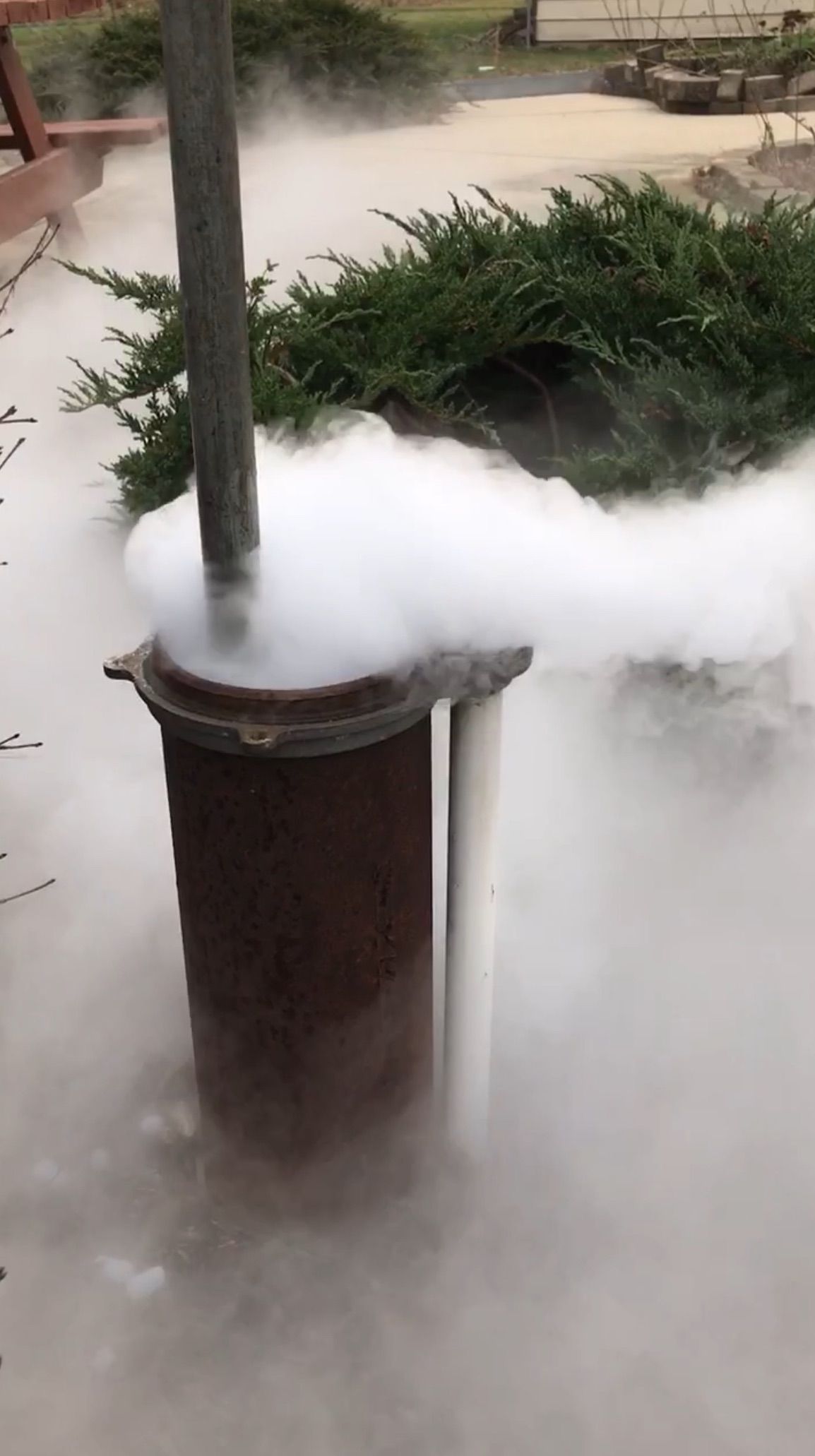 smoke is coming out of a pipe in a garden