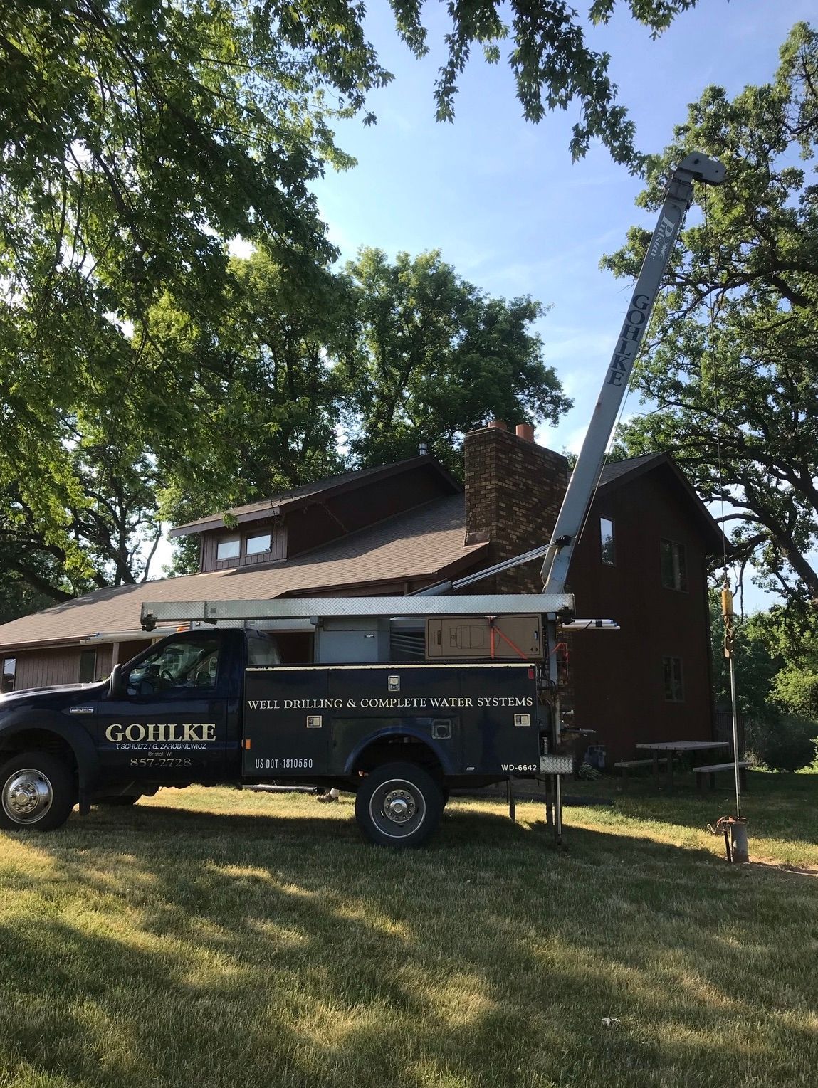 a truck with a crane attached to it is parked in front of a house