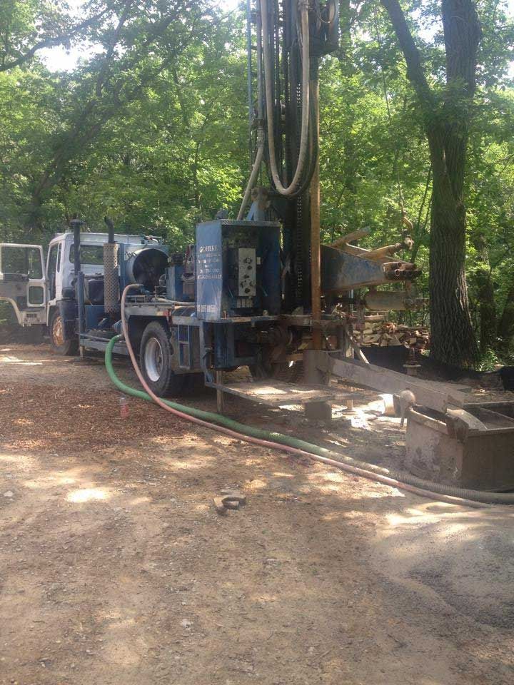 a truck is parked on a dirt road next to a tree