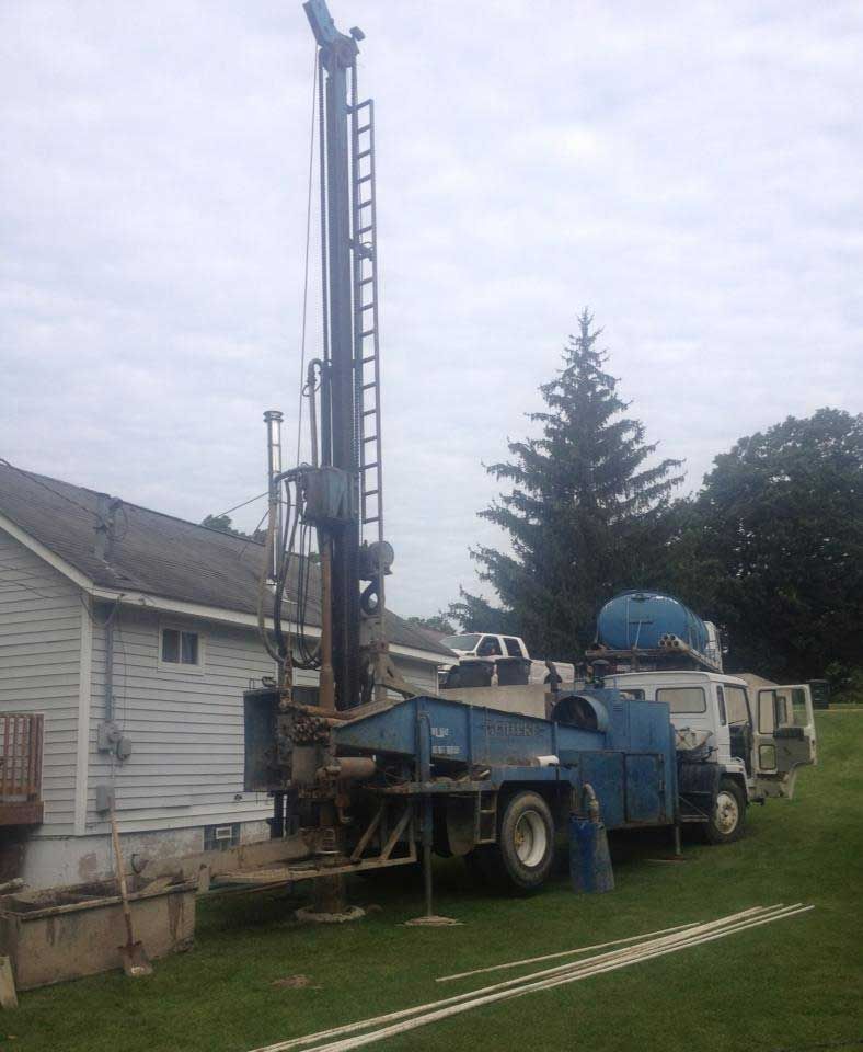 a blue truck is parked in front of a white house
