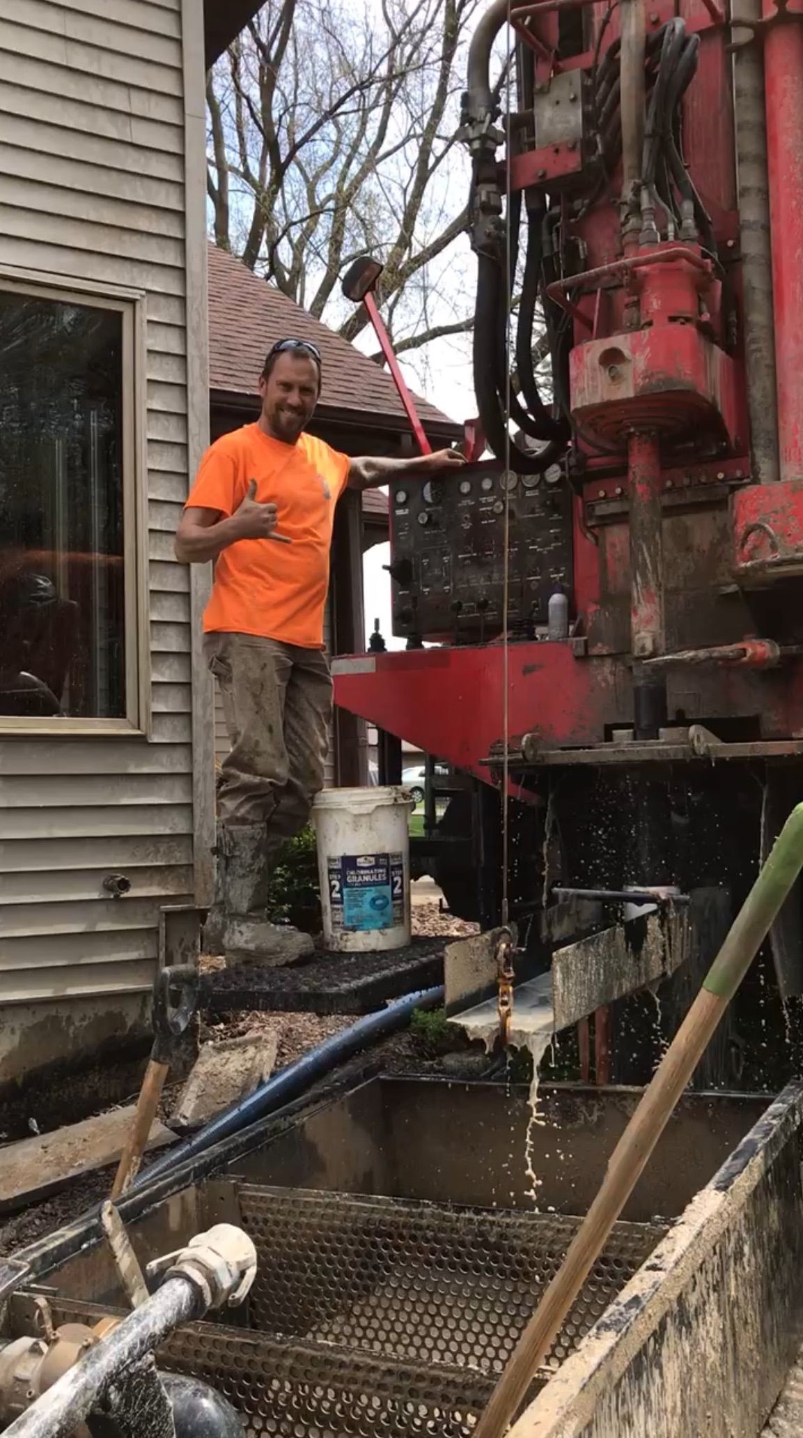 a man is standing next to a red truck in front of a house