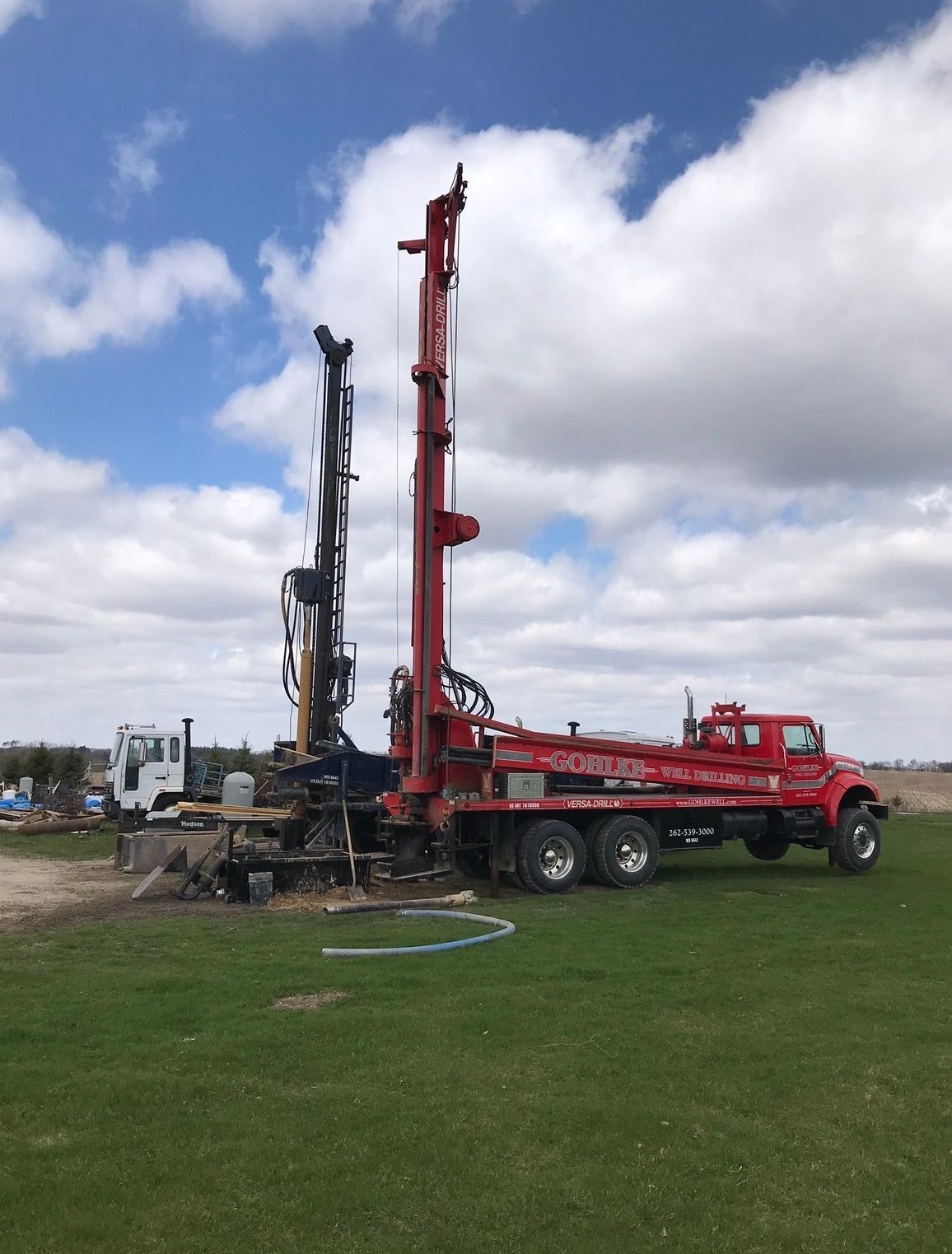 a red truck is parked in the middle of a grassy field