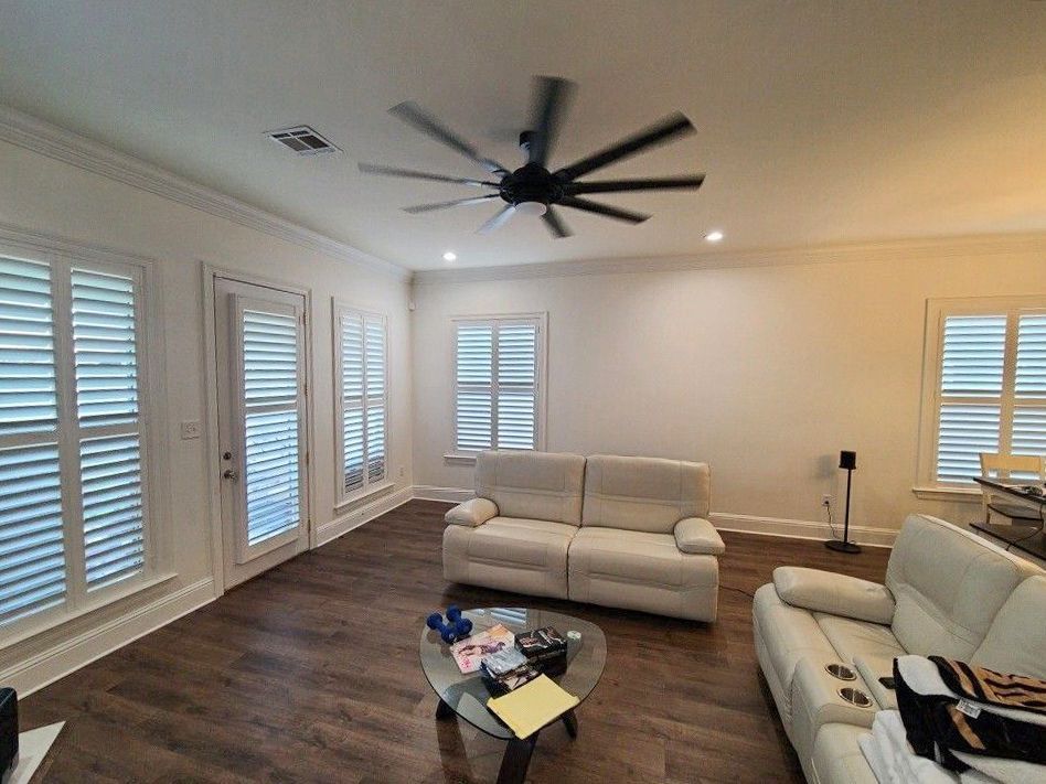 A living room with a couch , coffee table , and ceiling fan.