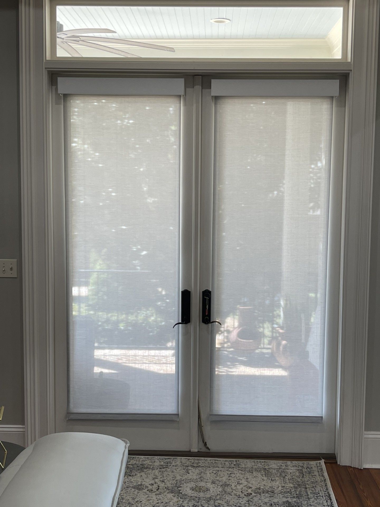 A living room with a sliding glass door with blinds on it.