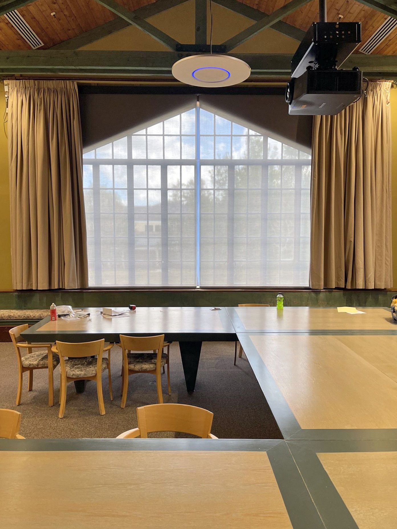 A conference room with tables and chairs and a large window