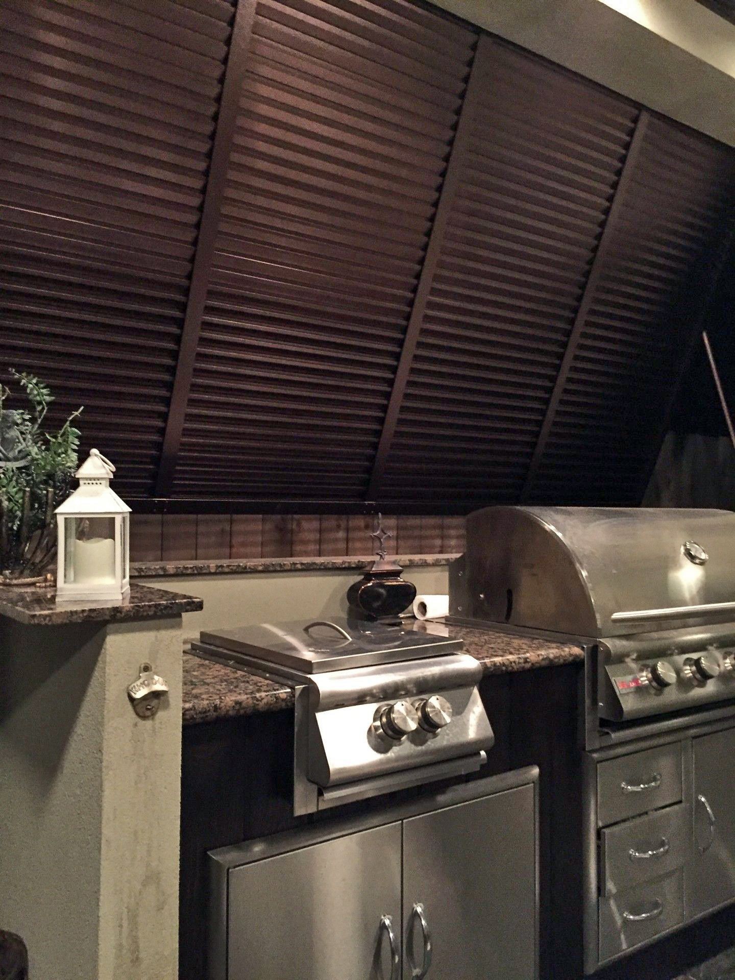 A kitchen with stainless steel cabinets and a grill