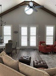 A living room with a couch , chairs , and a ceiling fan.