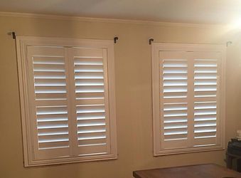 There are two windows with shutters on them in a room.