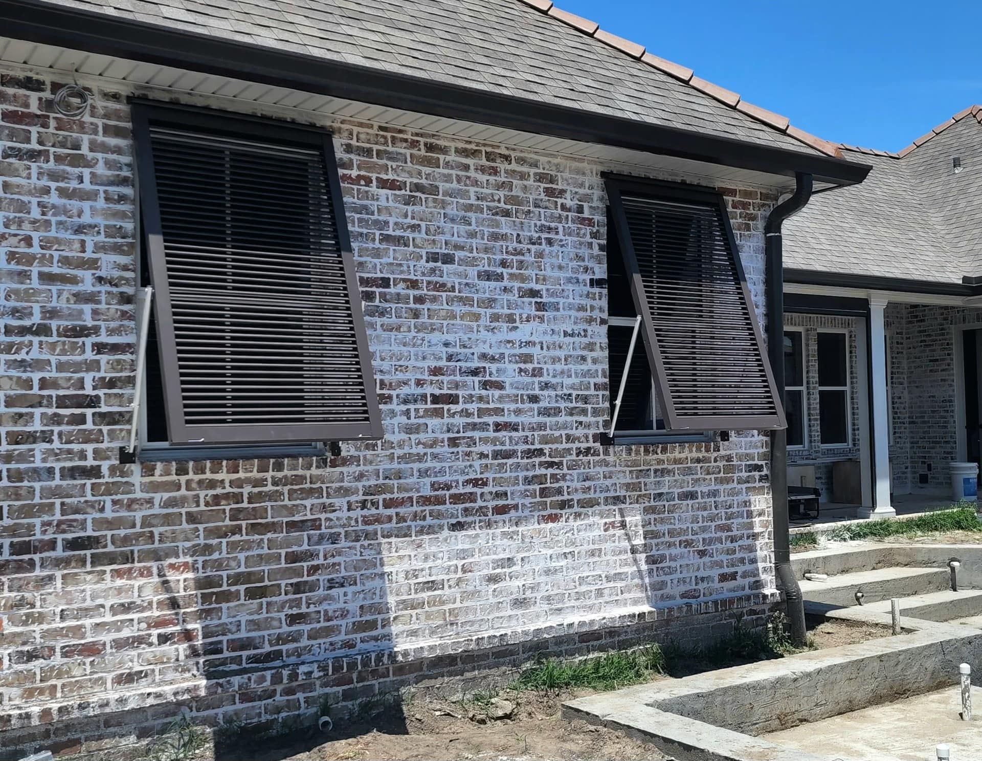 A white brick house with shutters on the windows