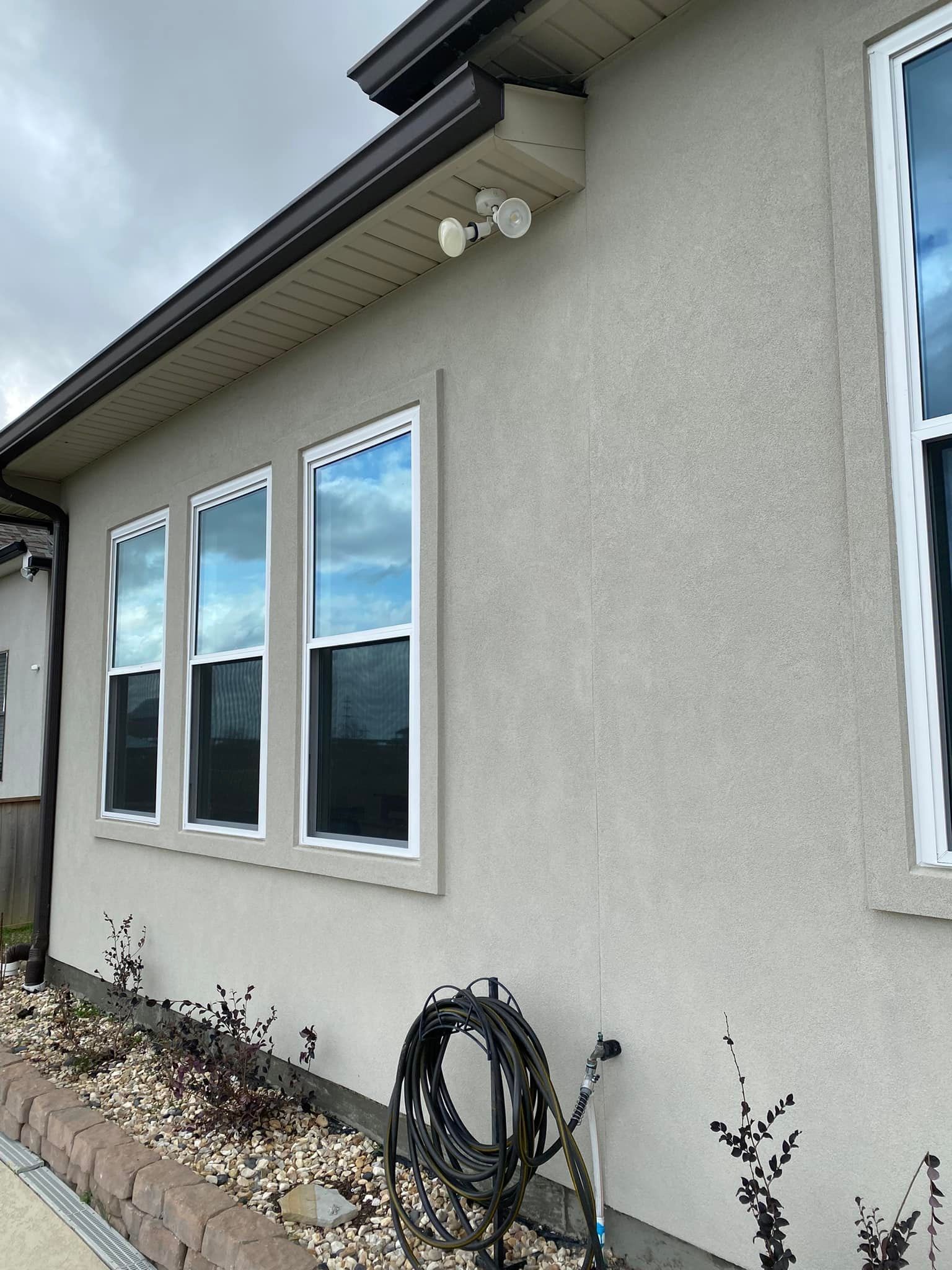 A house with a lot of windows and a hose on the side of it.