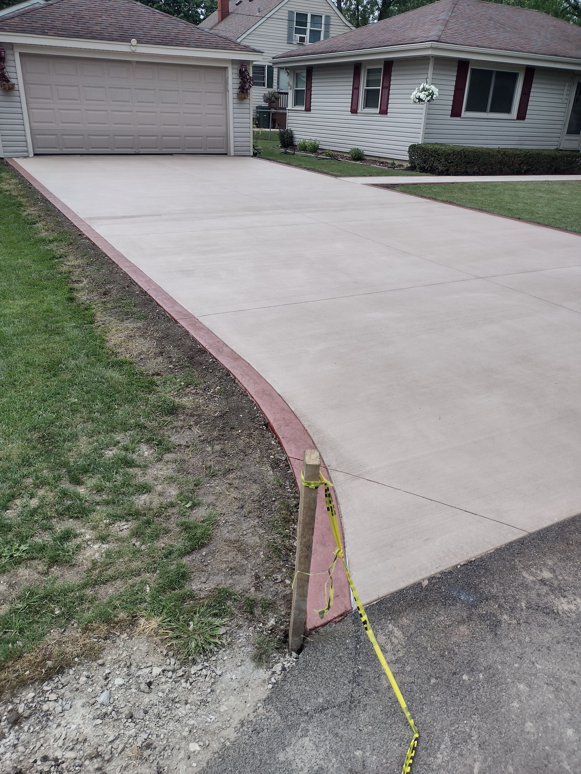A concrete driveway is being built in front of a house.